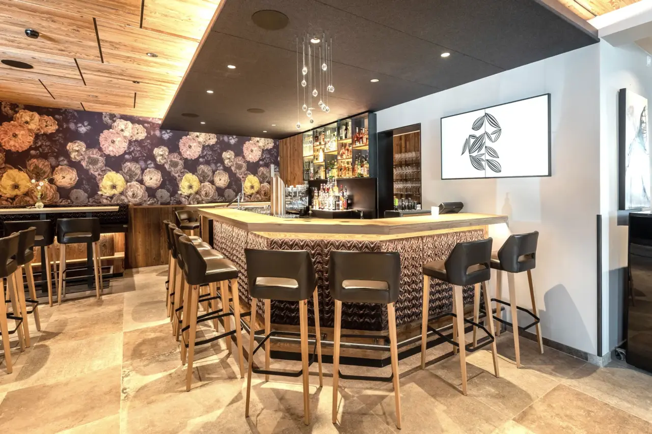 Moderne Bar mit Blumenwand und Sitzgelegenheiten