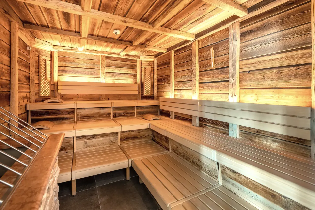 Leere Holzsauna mit Bänken und Wänden.