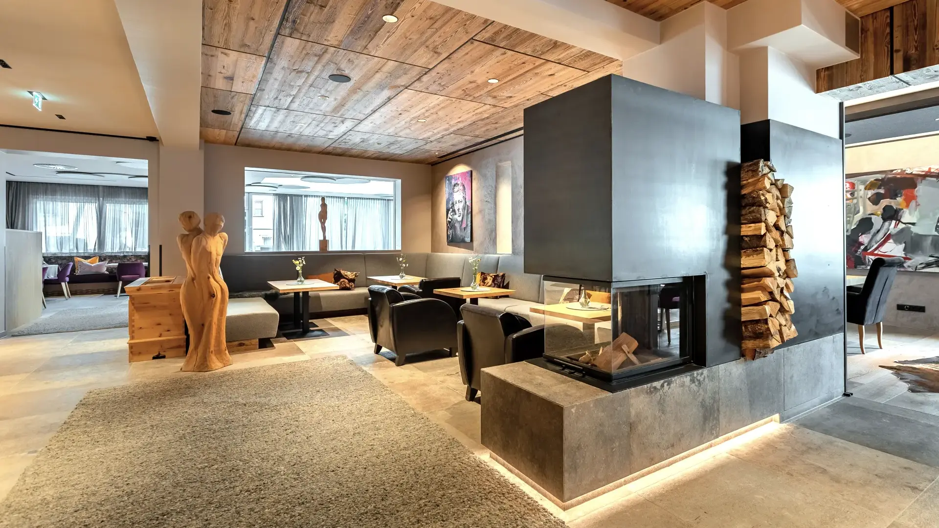 Moderner Wohnbereich mit Kamin und Holzstatuen