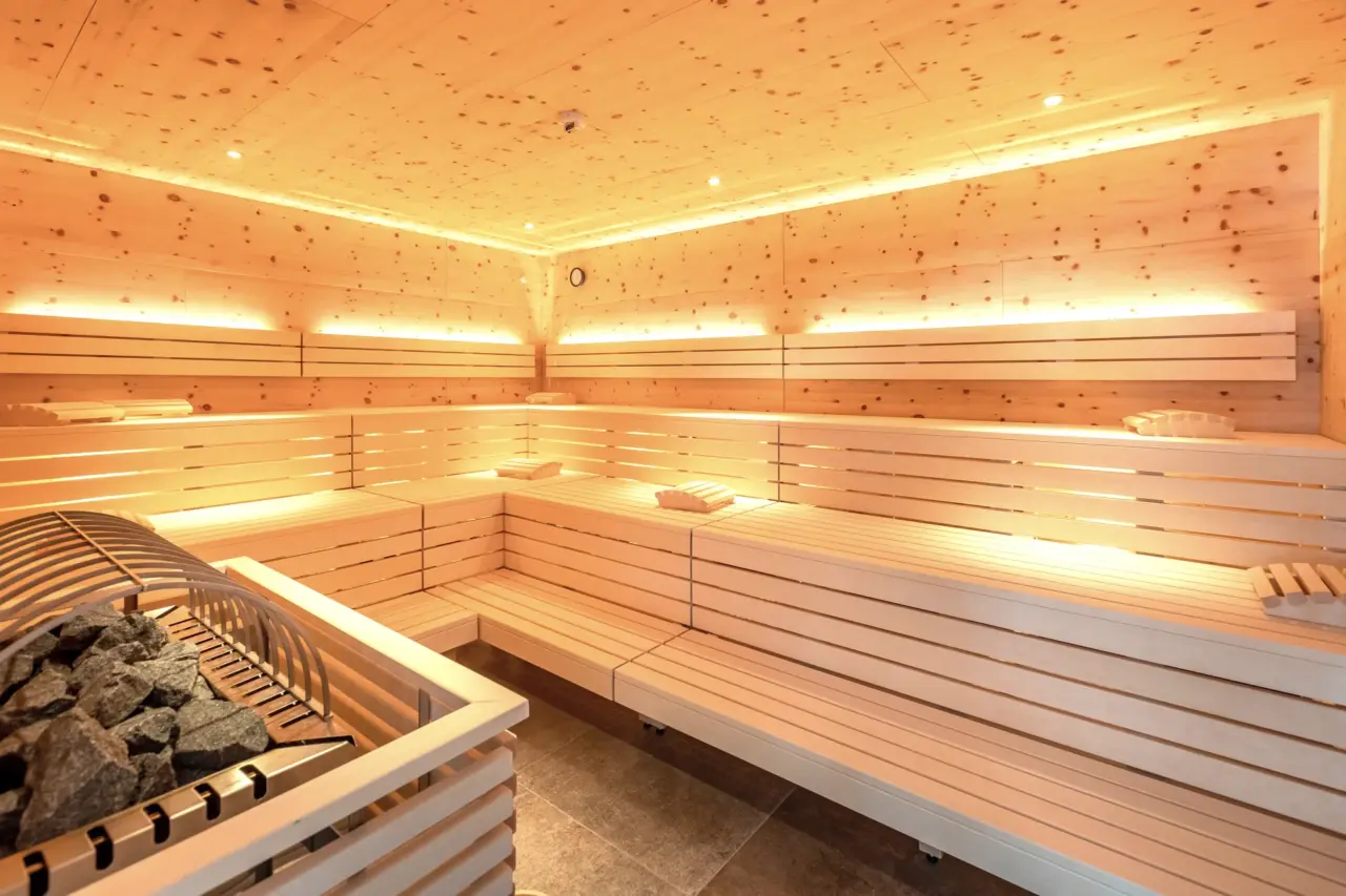 Moderne Holzsauna mit Sitzbänken und Steinen