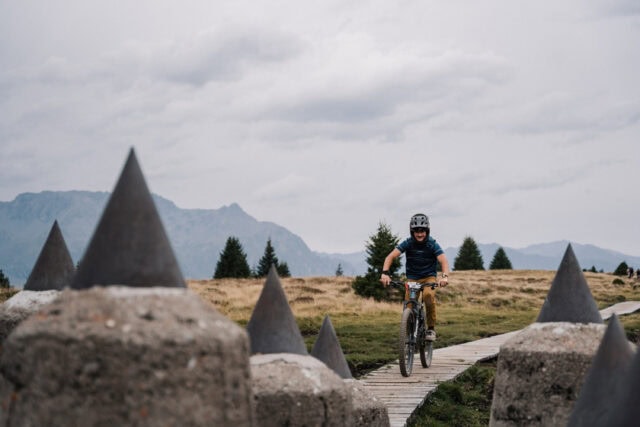 Mountainbiker auf Holzweg im Gebirge