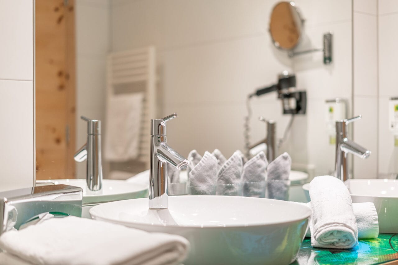 Waschbecken mit Handtüchern, Badezimmer im Naudererhof, komfortabel und stilvoll, perfekte Unterkunft in den Tiroler Alpen.