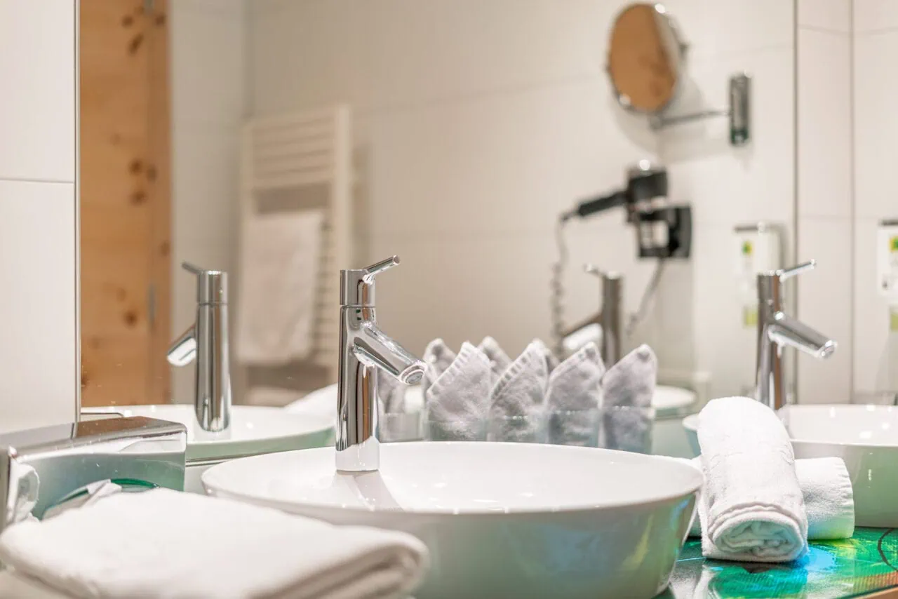 Waschbecken mit Handtüchern, Badezimmer im Naudererhof, komfortabel und stilvoll, perfekte Unterkunft in den Tiroler Alpen.