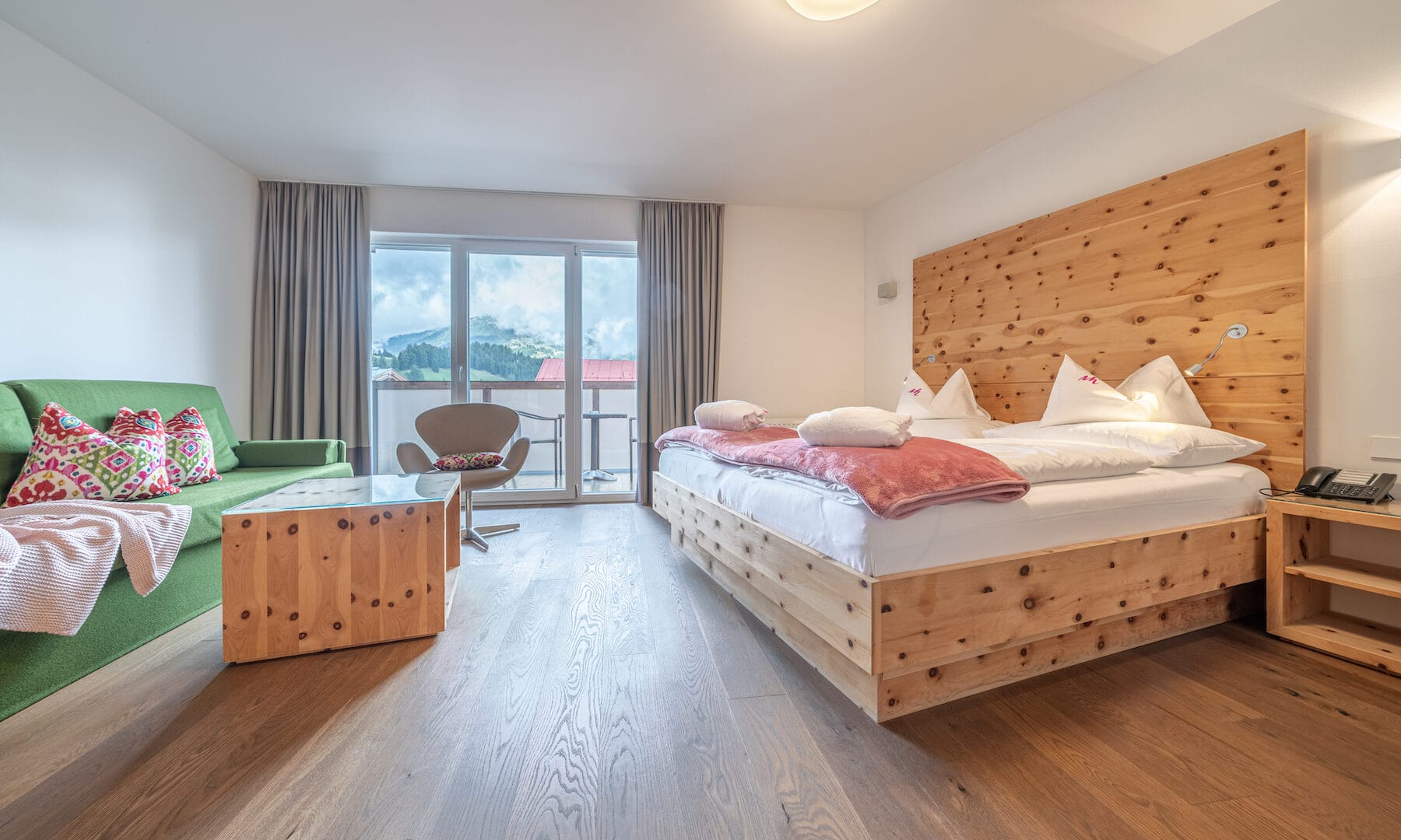Helles Hotelzimmer mit Holzdetails und Bergblick