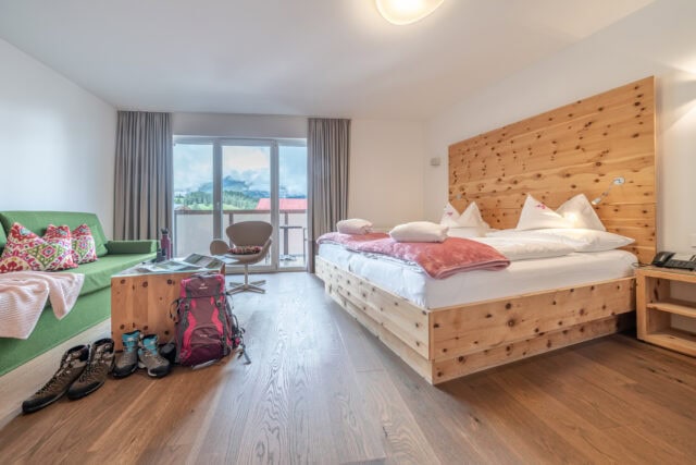 Gemütliches Hotelzimmer mit Bergblick und Wanderausrüstung.