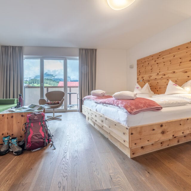Gemütliches Hotelzimmer mit Bergblick und Wanderausrüstung.