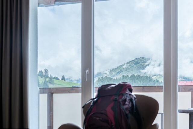 Aussicht auf bergige Landschaft durch Fenster.