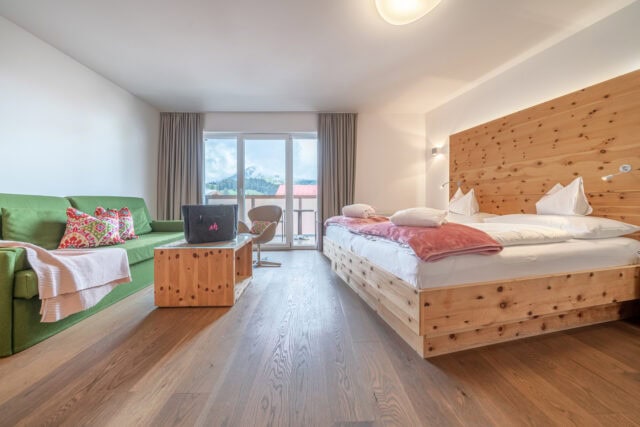 Modernes Hotelzimmer mit Holzmöbeln und Bergblick.