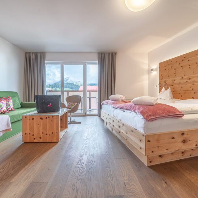 Modernes Hotelzimmer mit Holzmöbeln und Bergblick.