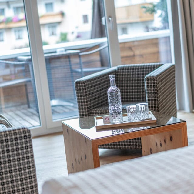 Durchblick auf Balkon mit Glasfront und Sitzmöbel im Naudererhof in Tirol.