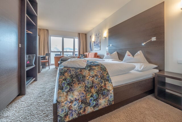 Gemütliches Hotelzimmer im Naudererhof mit modernem Dekor und Balkonblick.