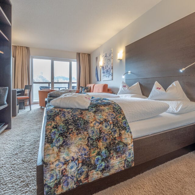 Gemütliches Hotelzimmer im Naudererhof mit modernem Dekor und Balkonblick.