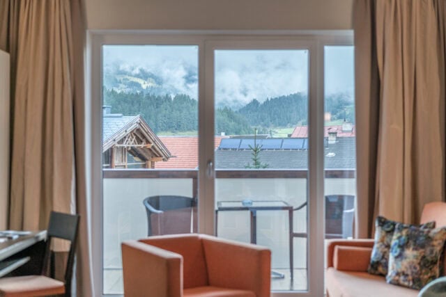 Gemütliches Hotelzimmer mit Balkon und Blick auf die Berge in Naudererhof, Tirol, Österreich.