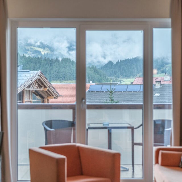 Gemütliches Hotelzimmer mit Balkon und Blick auf die Berge in Naudererhof, Tirol, Österreich.