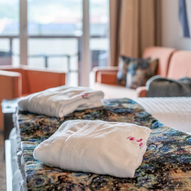 Gemütliche Hotelzimmer im Naudererhof mit komfortablen Betten und Handtüchern.