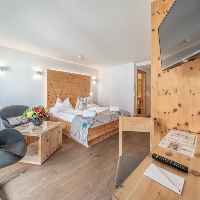 Gemütliches Hotelzimmer im Naudererhof mit Holzdetails und Komfort.