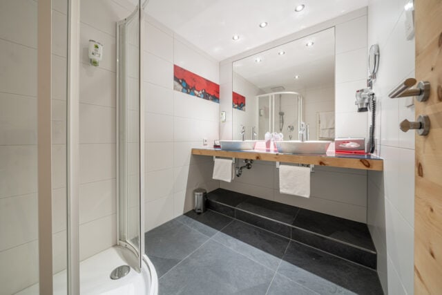 Modernes Badezimmer mit Dusche und großem Spiegel