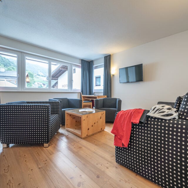 Helles Wohnzimmer mit Polstermöbeln und Holzfußboden.