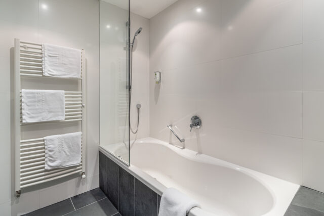 Moderne Badezimmer mit Badewanne und Handtuchhalter.