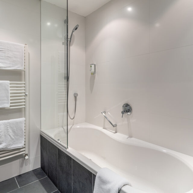 Moderne Badezimmer mit Badewanne und Handtuchhalter.
