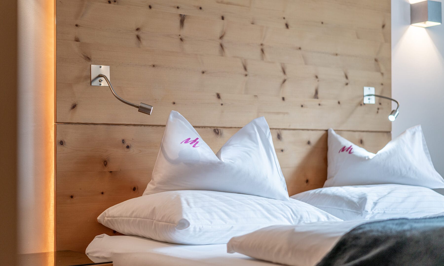 Doppelbett mit Holzrückwand und Kissen