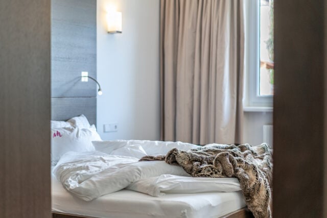 Unordentliches Bett im gemütlichen Schlafzimmer