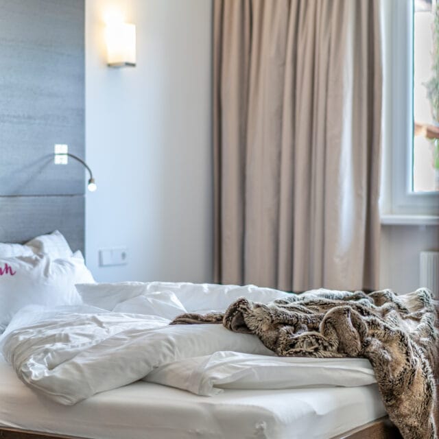 Unordentliches Bett im gemütlichen Schlafzimmer