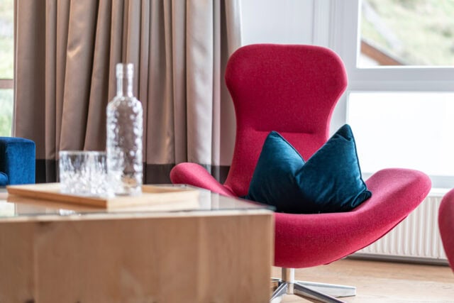 Roter Sessel mit Kissen im Wohnzimmer.