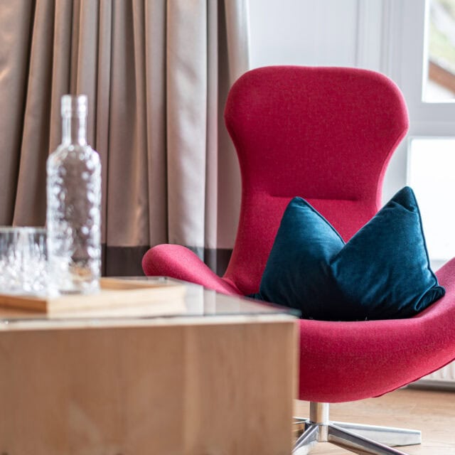 Roter Sessel mit Kissen im Wohnzimmer.