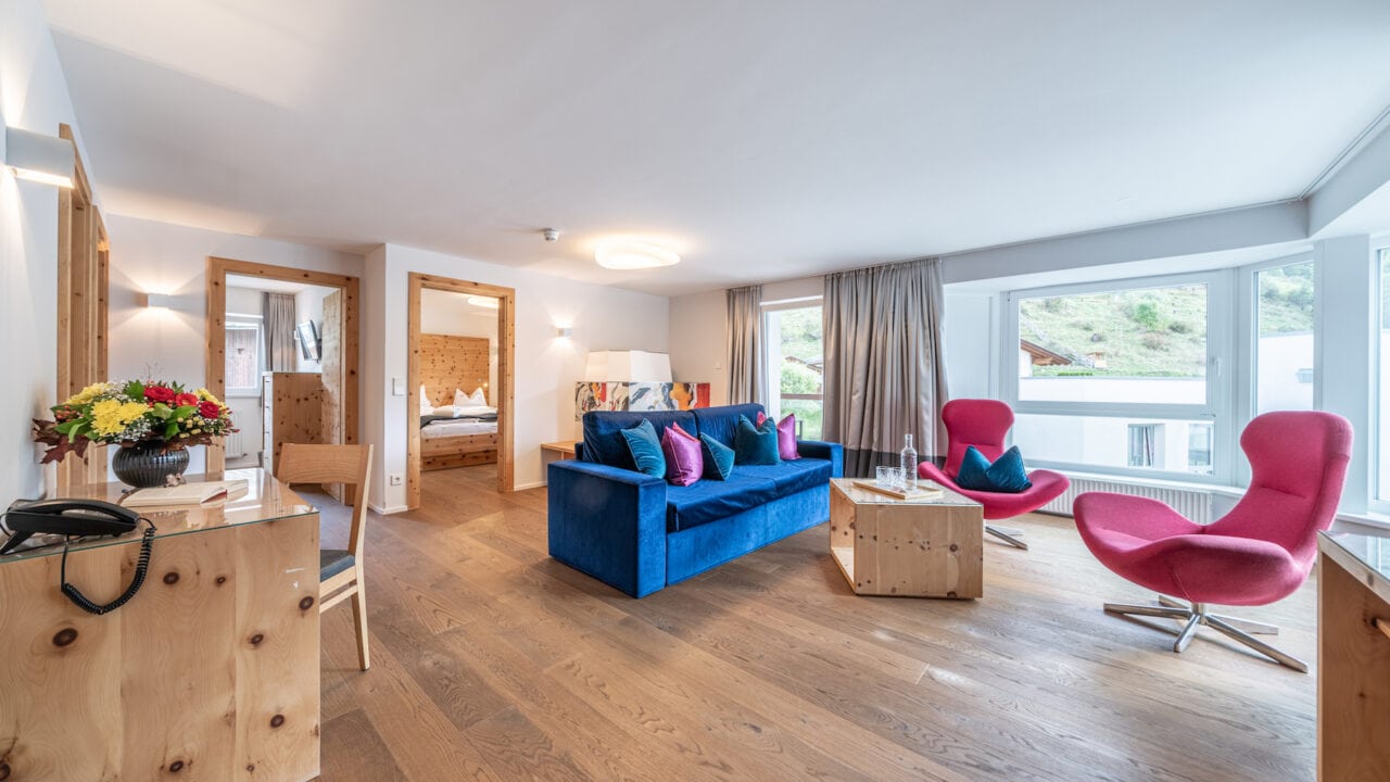 Modernes Wohnzimmer mit bunten Möbeln und Holzboden.