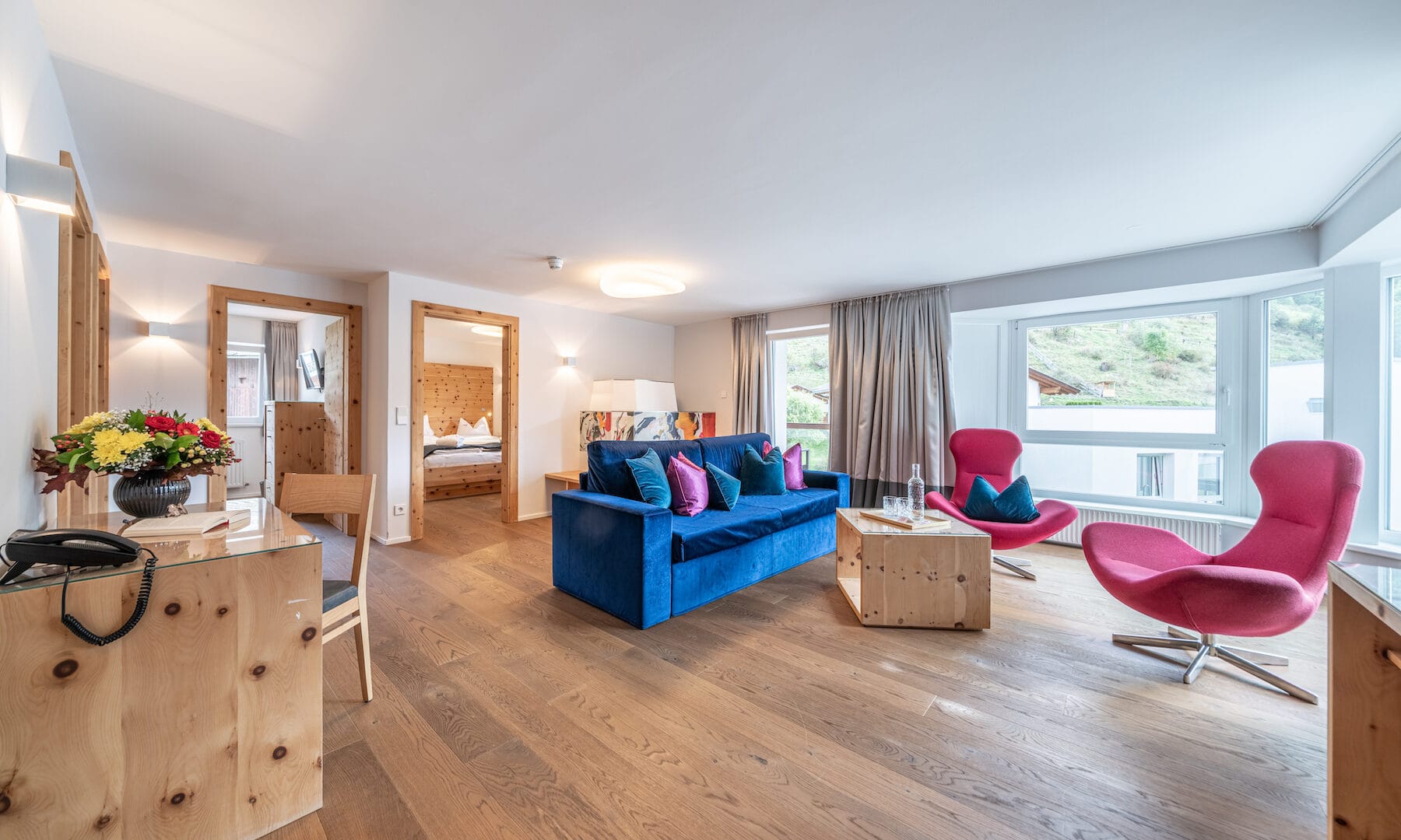 Modernes Wohnzimmer mit bunten Möbeln und Holzboden.