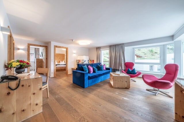 Modernes Wohnzimmer mit bunten Möbeln und Holzboden.