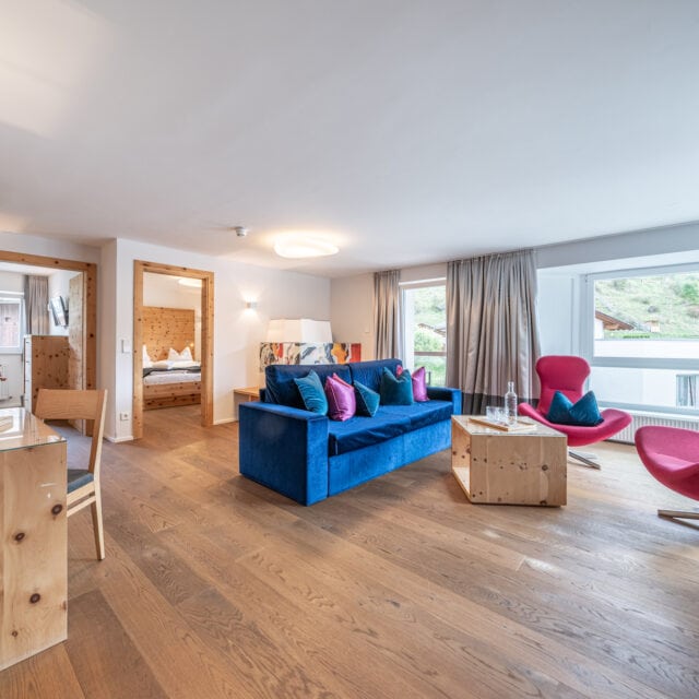 Modernes Wohnzimmer mit bunten Möbeln und Holzboden.