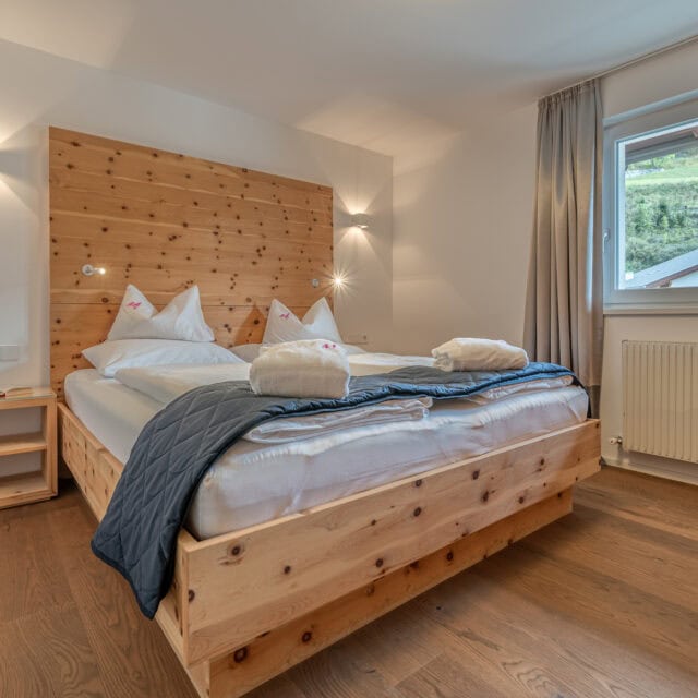 Gemütliches Schlafzimmer mit Holzinterieur und Fensterblick.