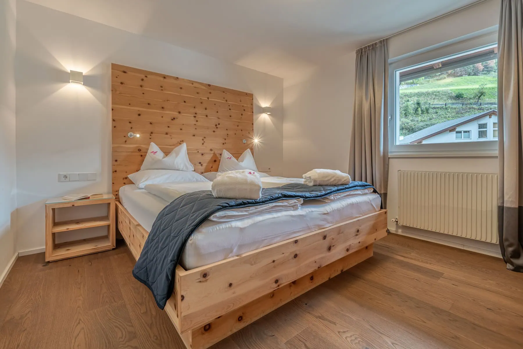 Gemütliches Hotelzimmer im Naudererhof mit Holzdeko und Bergblick, perfekte Unterkunft in den Tiroler Alpen.