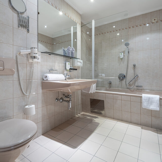 Sauberes Badezimmer mit Dusche und Badewanne, inklusive Haartrockner und Handtücher, im Naudererhof.