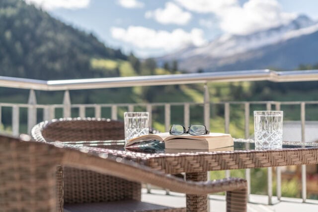 Terrasse mit Buch, Brille und Wassergläsern