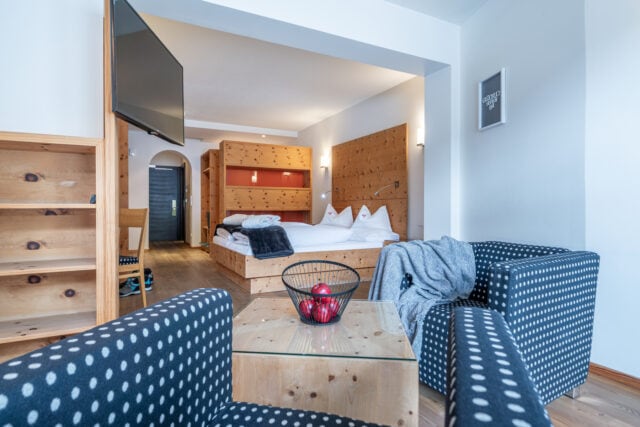 Gemütliches Hotelzimmer im Naudererhof mit Holzdekoration, komfortable Betten und moderner Ausstattung.