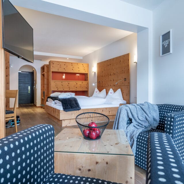Gemütliches Hotelzimmer im Naudererhof mit Holzdekoration, komfortable Betten und moderner Ausstattung.