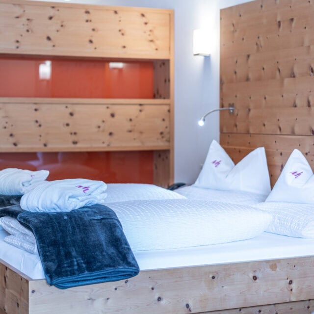 Hotelzimmer mit Holzmöbeln und Doppelbett