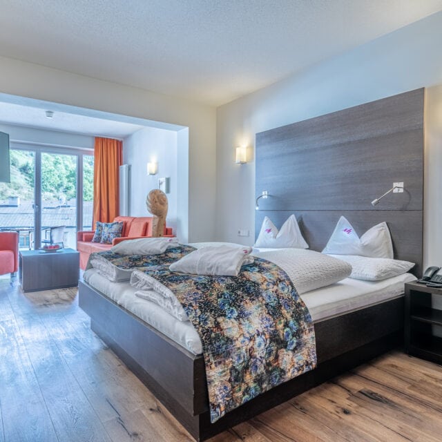 Modernes Hotelzimmer mit Doppelbett und Balkon