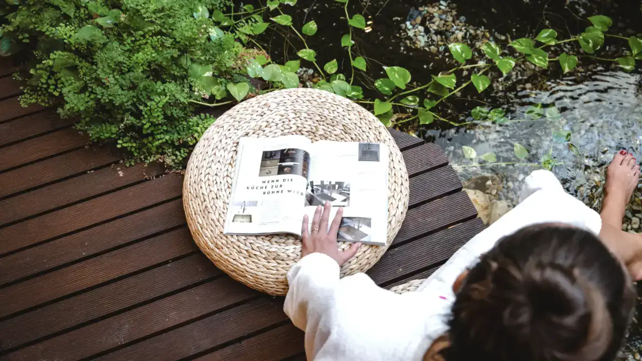 Entspannende Regentag im Naudererhof, Frau liest magazines am Seeufer, Natur, Ruhe, Erholung.