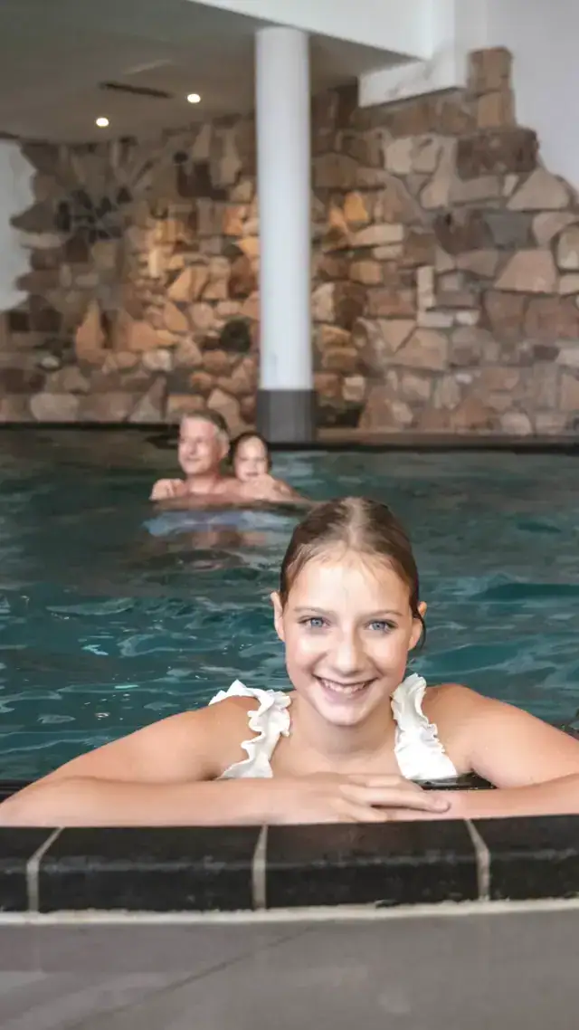 Familie im Indoor-Pool mit Kind das lacht