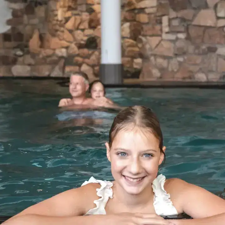 Familie im Indoor-Pool mit Kind das lacht