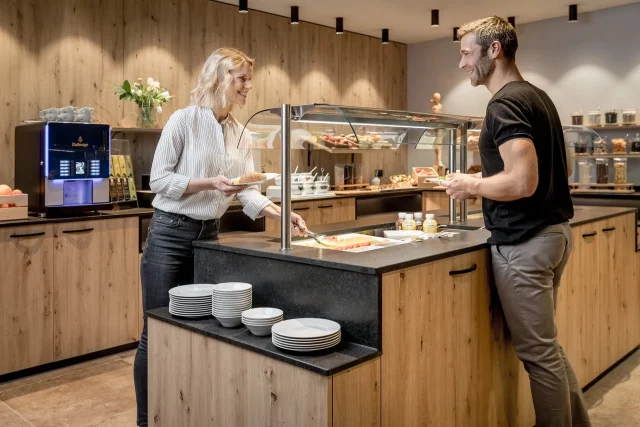 Menschen am Frühstücksbuffet im Holzeinrichtungsstil