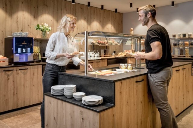 Menschen am Frühstücksbuffet im Holzeinrichtungsstil