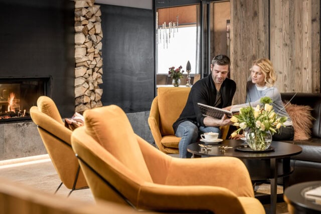 Paar entspannen am Kamin mit Buch
