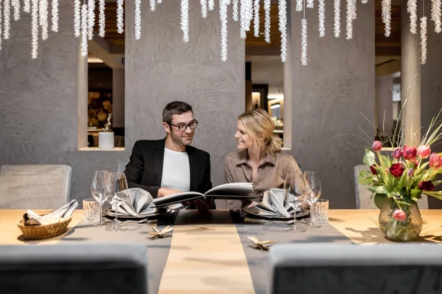 Paar diskutiert Menü in elegantem Restaurantambiente.