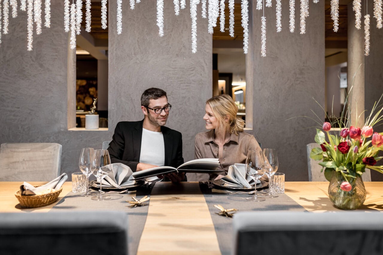 Paar diskutiert Menü in elegantem Restaurantambiente.