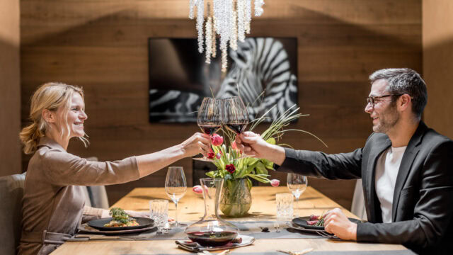 Paar stößt mit Wein im Restaurant an.